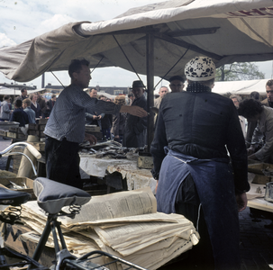 859531 Afbeelding van verkopers bij een viskraam op de markt op het Paardenveld te Utrecht.